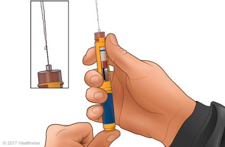 Priming the needle, with close-up of insulin coming out of the needle